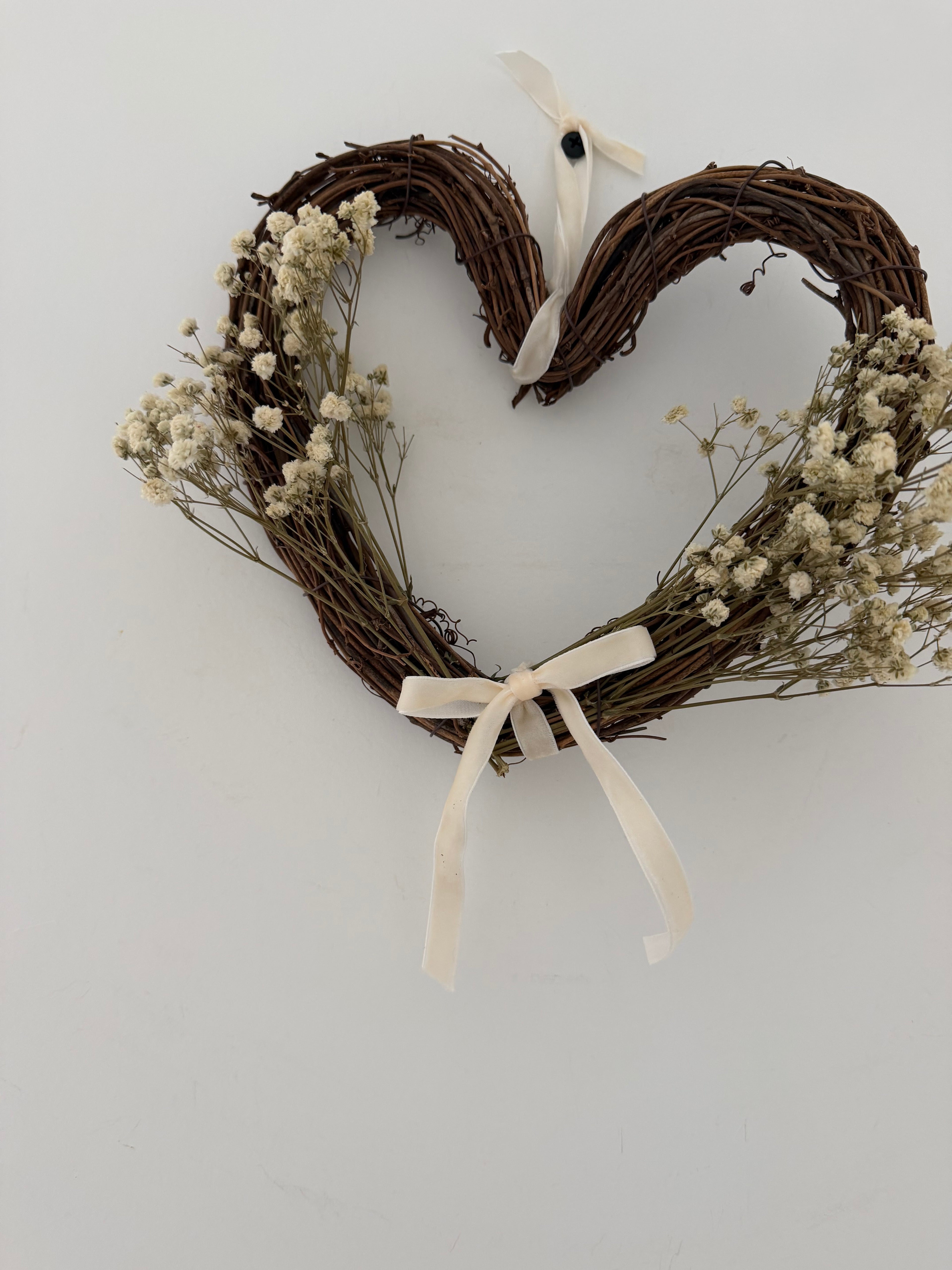 20cm heart wreath with gypsophilas finished with a ivory velvet bow