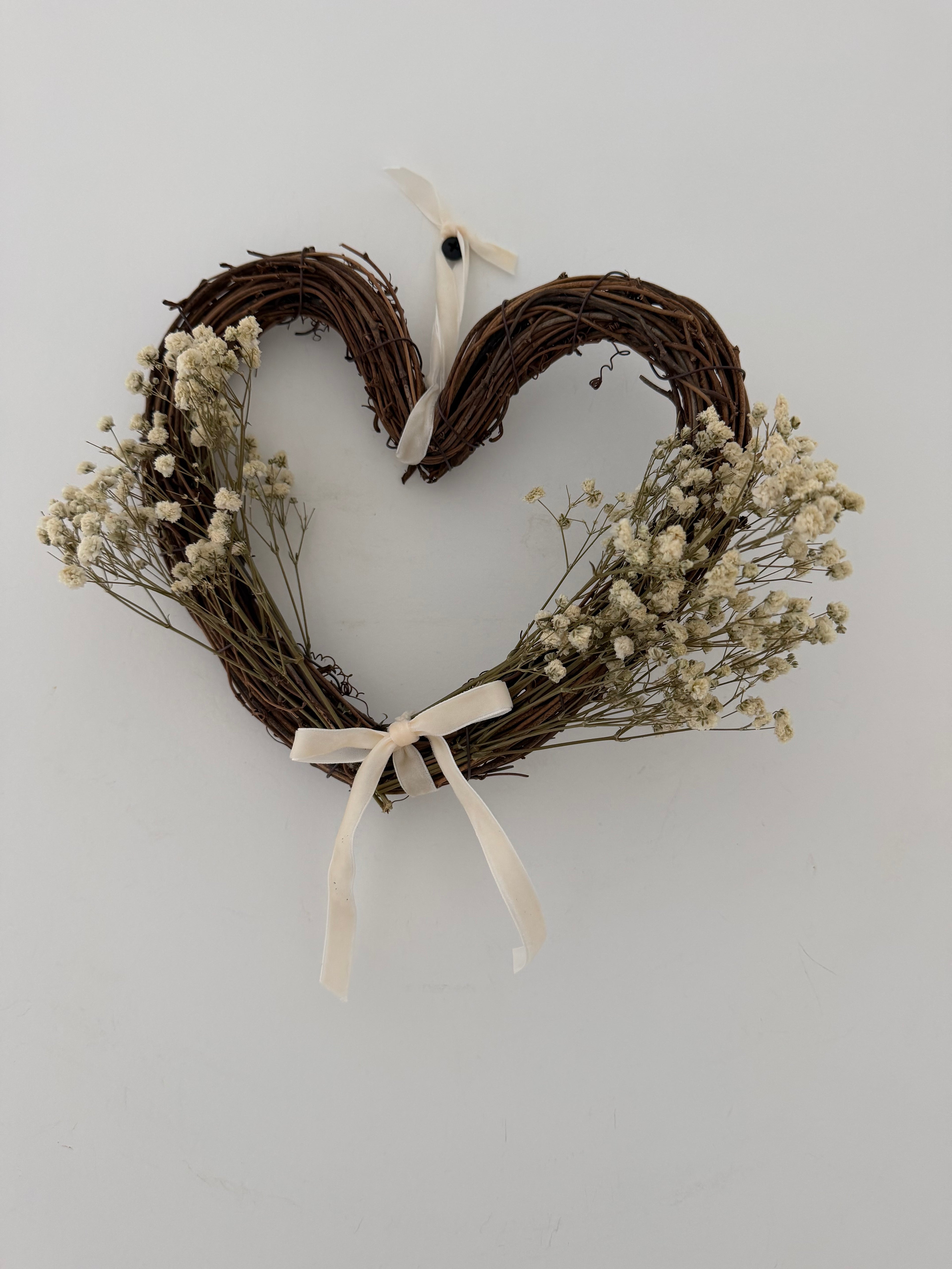 20cm heart wreath with gypsophilas finished with a ivory velvet bow