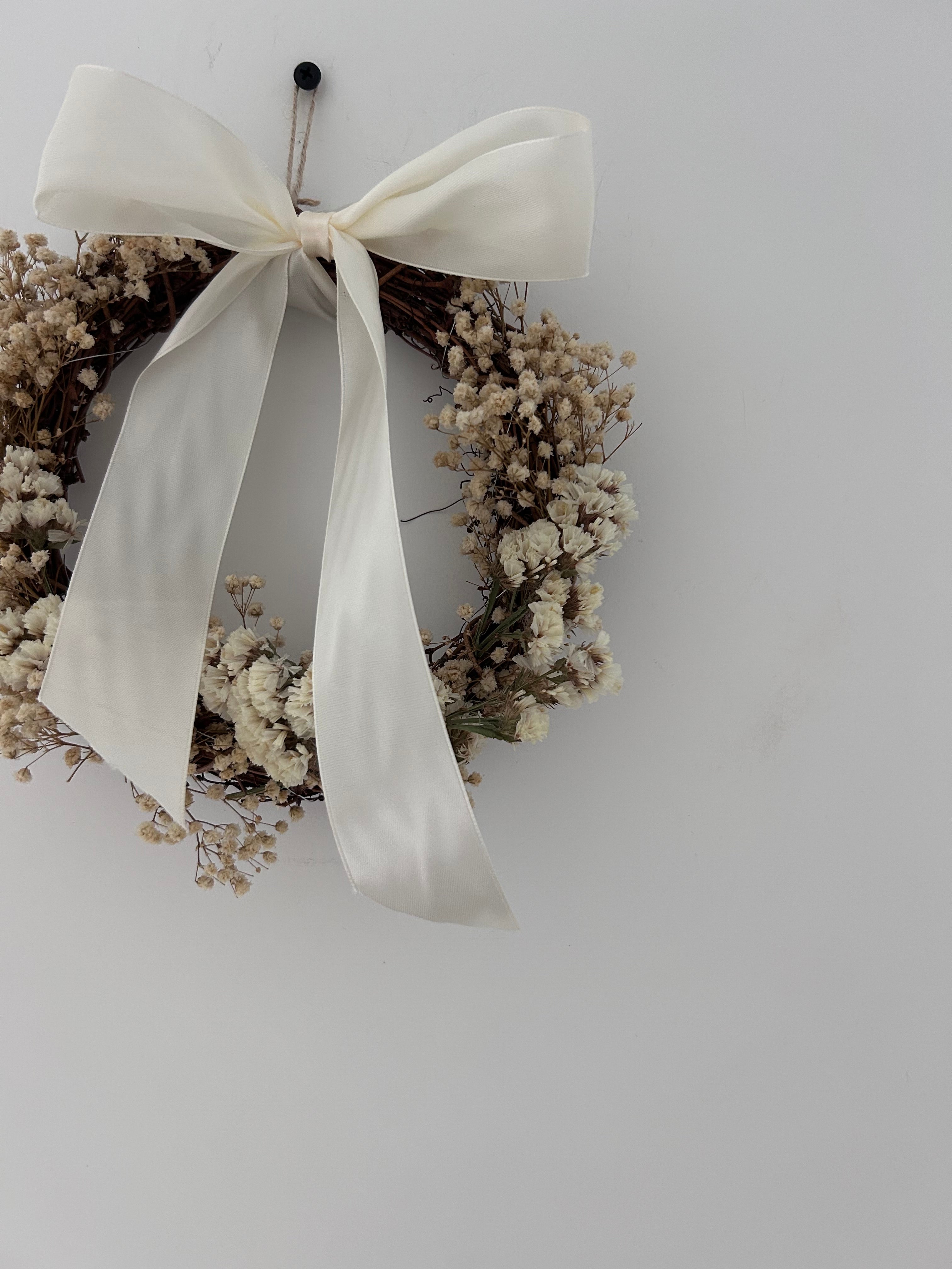 ‘Luchia’ Wreath with white statice, gypsophilas finished with a cream bow