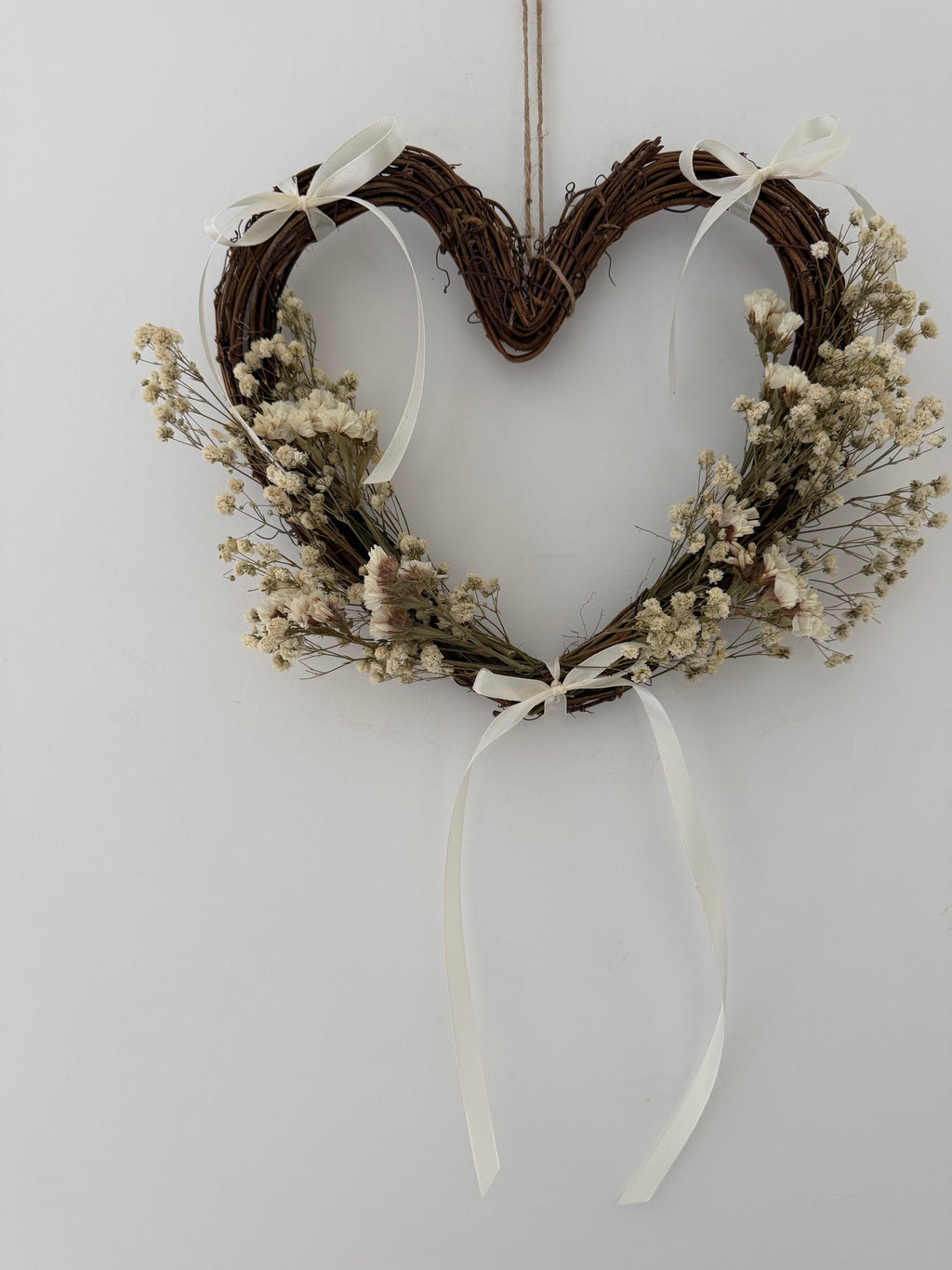 25cm heart wreath with white statice, gypsophilas finished with ivory bows
