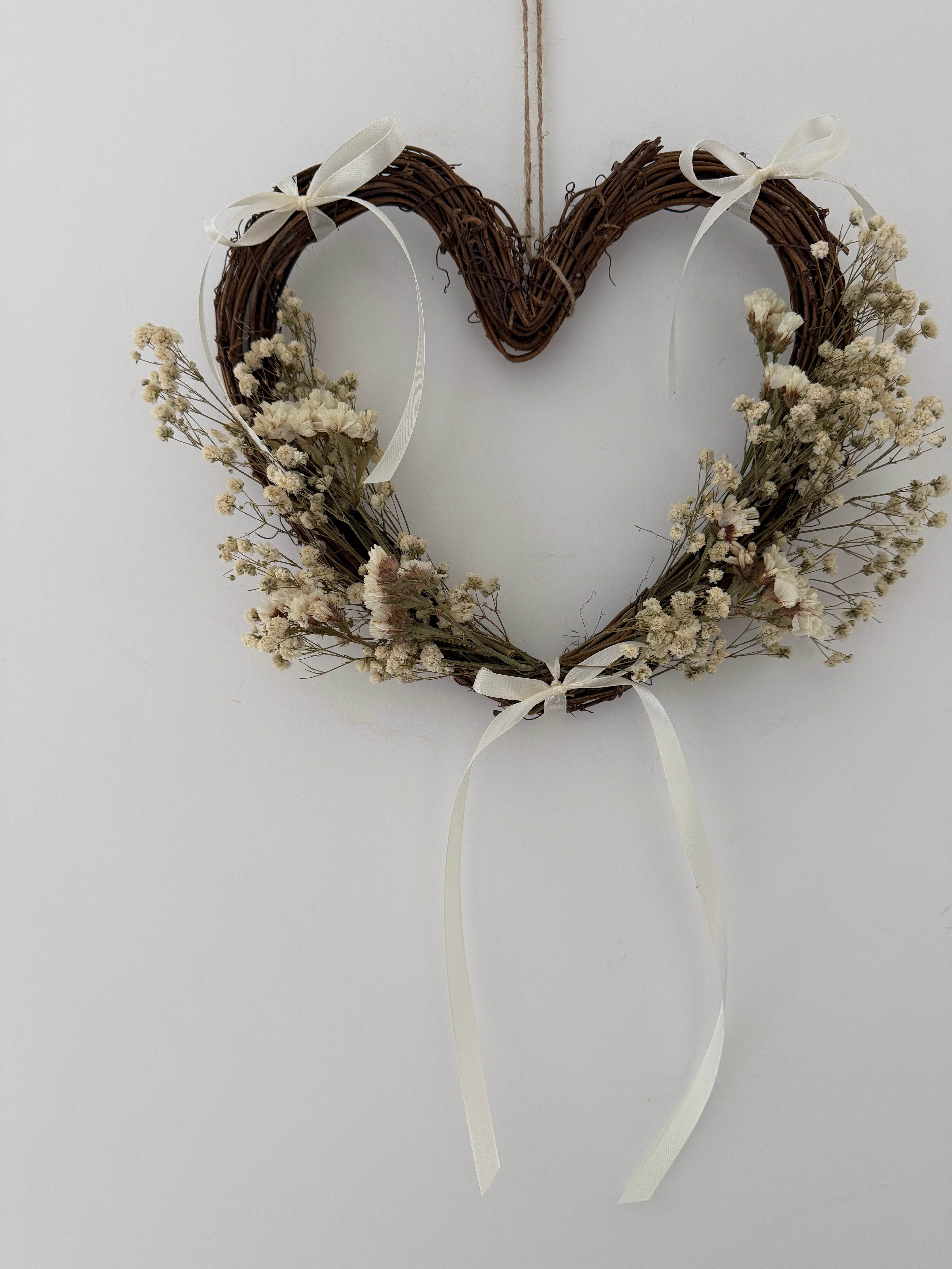 25cm heart wreath with white statice, gypsophilas finished with ivory bows