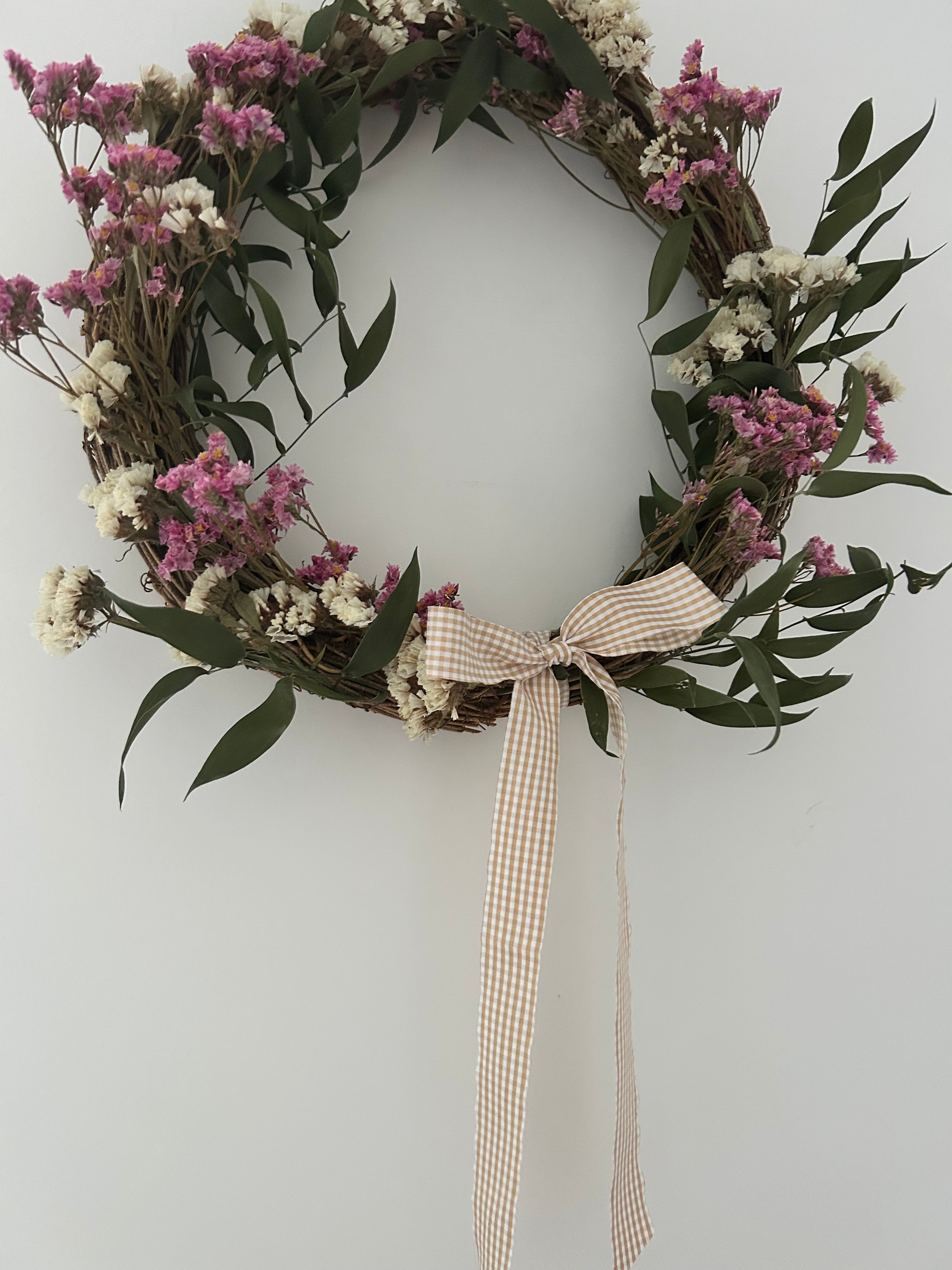 Mabel’ Wreath with Pink Limonium, White Statice, Ruscus finished with a beige gingham bow 30cm