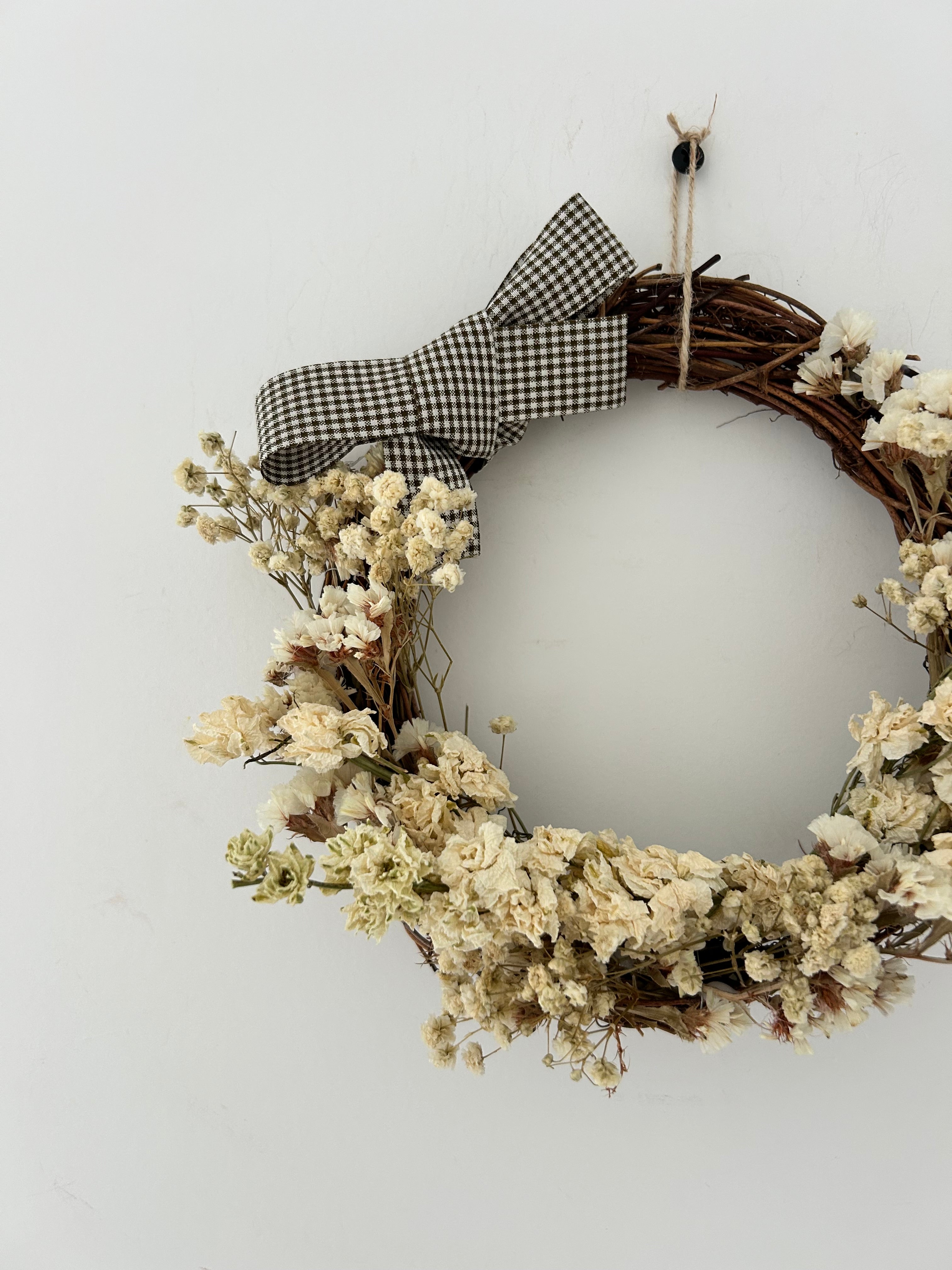 ‘Magnolia’ Wreath with White Delphinium, White Statice & Gypsophilas finished with a dark brown gingham bow 20cm