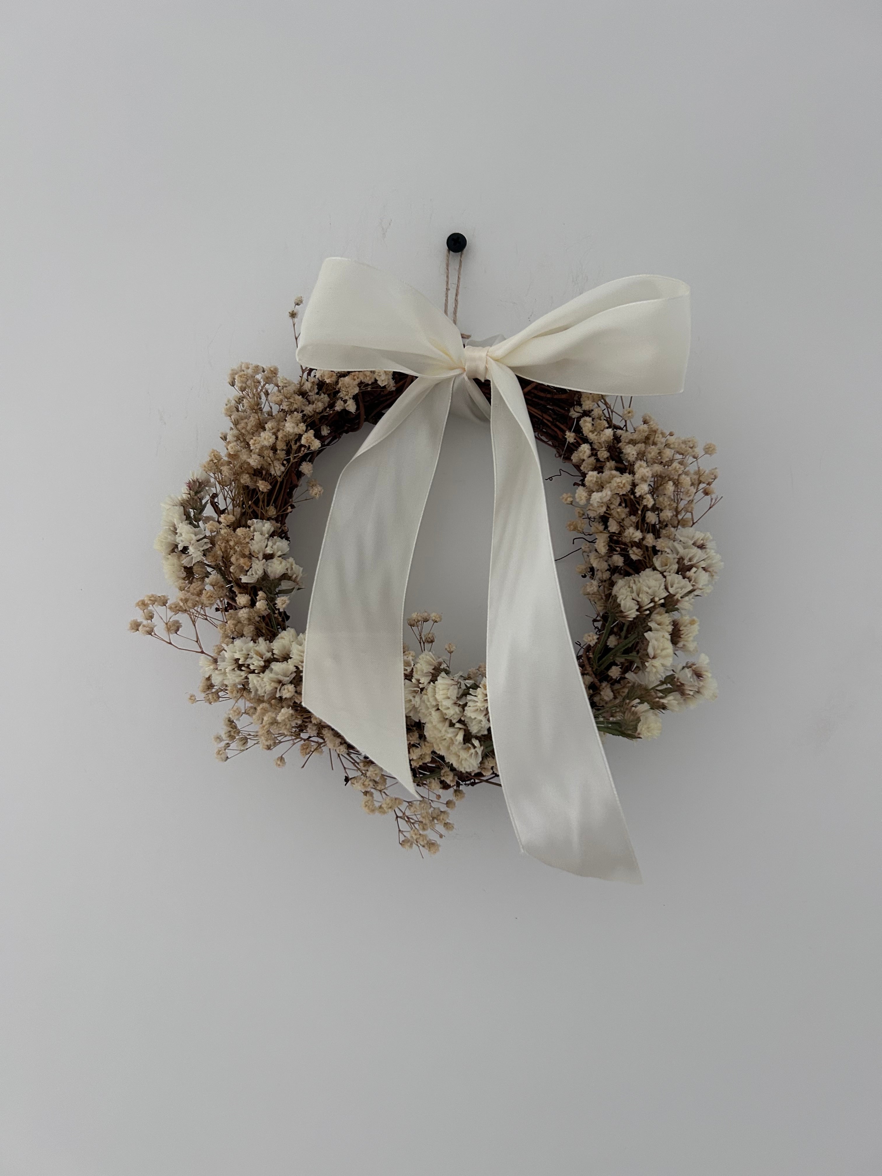 ‘Luchia’ Wreath with white statice, gypsophilas finished with a cream bow