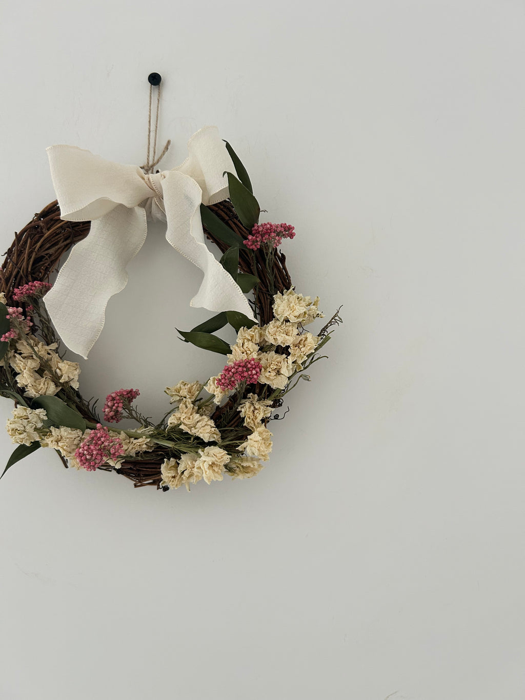 ‘Everlee’ Wreath with White Delphinium’s, Pink Rice Flowers and Ruscus finished with a cream bow 20cm