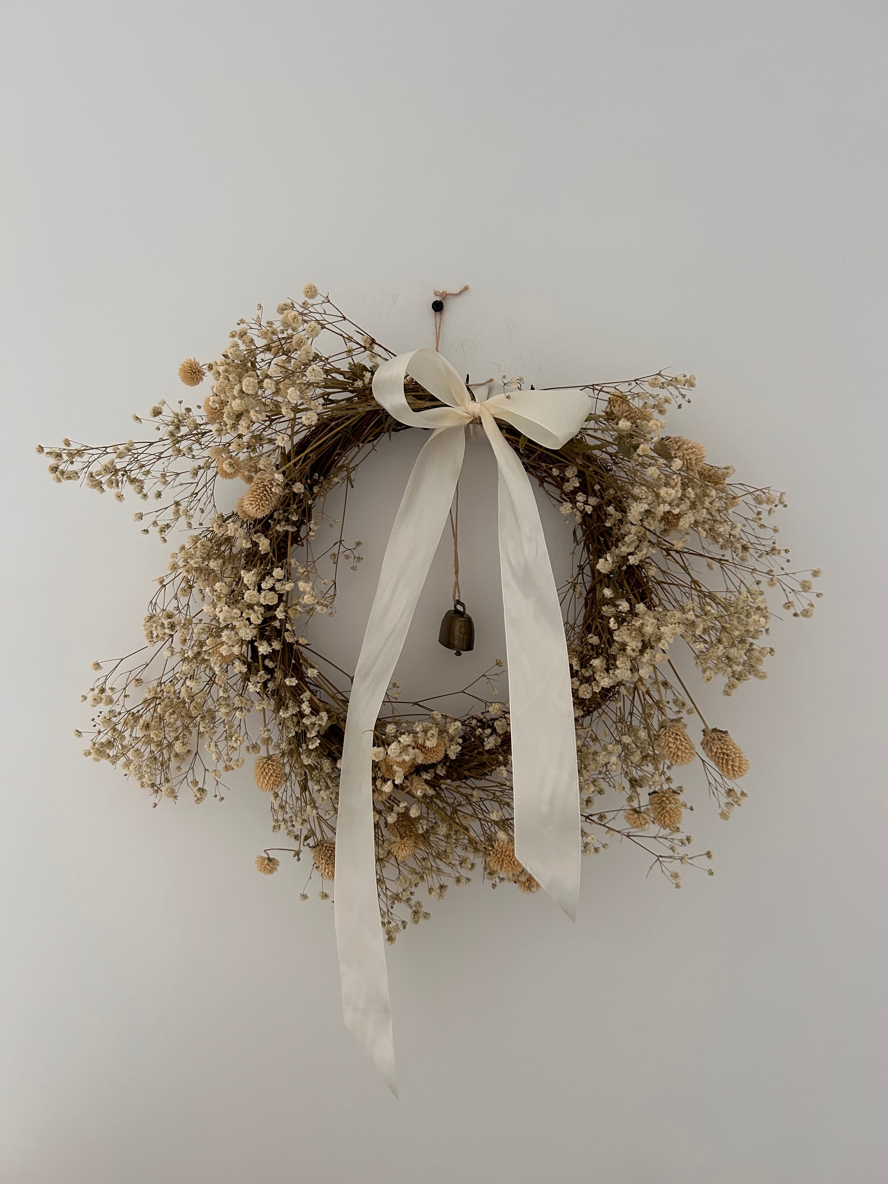 ‘Zara’ Wreath with Gomphrena’s & Gypsophila’s finished with an ivory bow and bell 30cm